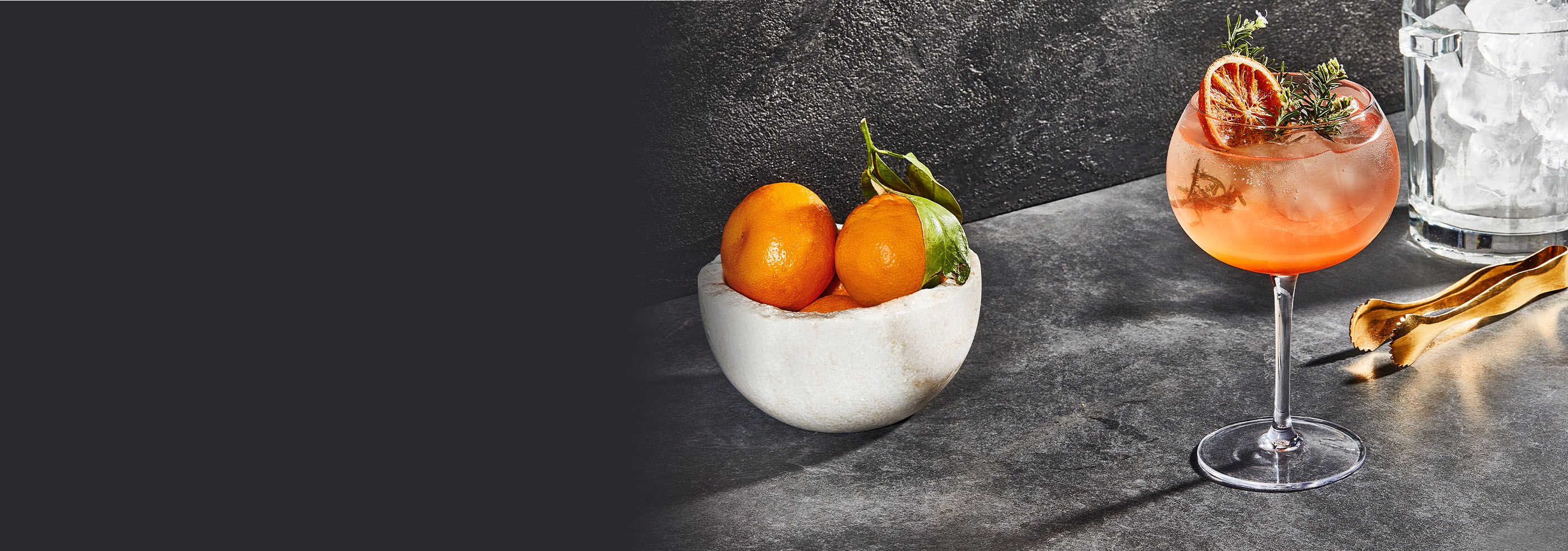 Image of a Spritz, served on a slate tray with a bowl of oranges next to it.